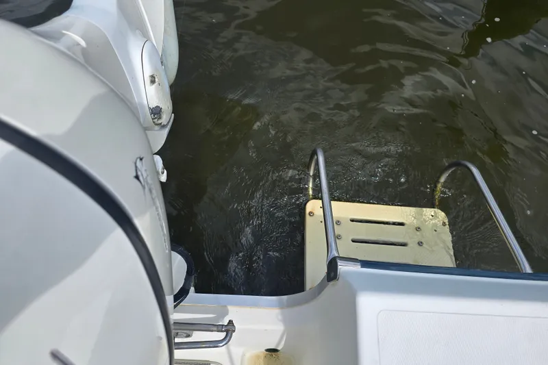Slide: The Image of 2004 Sea Boss 180 Center Console boat with swim ladder and outboard motor on water. - 21