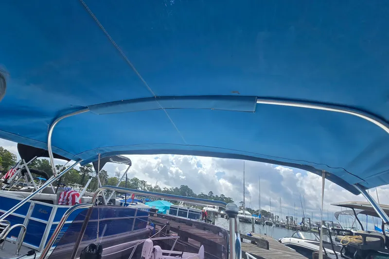 Slide: The Image of 2004 Sea Boss 180 Center Console boat with blue canopy at marina. - 9