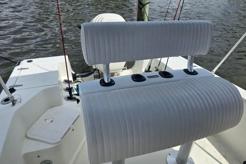 Slide: The Image of 2004 Sea Boss 180 Center Console boat with cushioned seating and fishing rods on a calm waterway. - 14