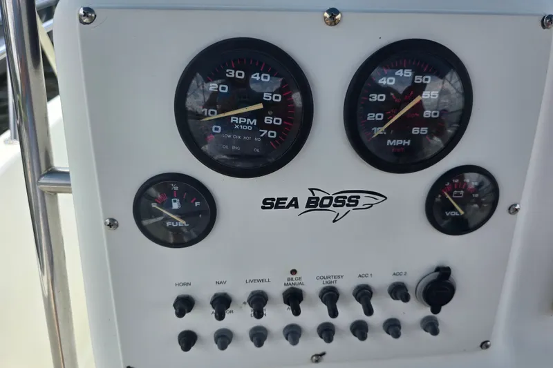 Slide: The Image of Dashboard of a 2004 Sea Boss 180 Center Console boat with gauges and controls. - 24