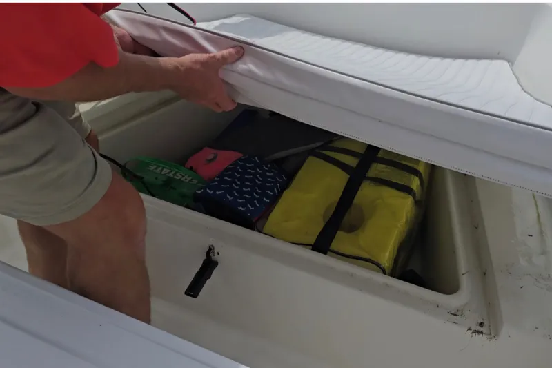 Slide: The Image of Man accessing storage compartment on 2004 Sea Boss 180 Center Console boat. - 12