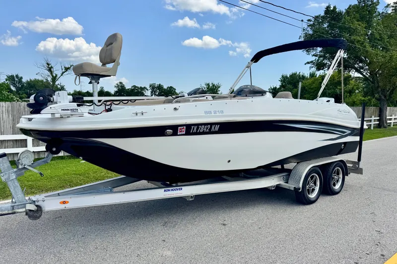 The Image of 2022 Hurricane Sundeck Sport 218 OB boat on trailer, parked on a suburban street. - 1