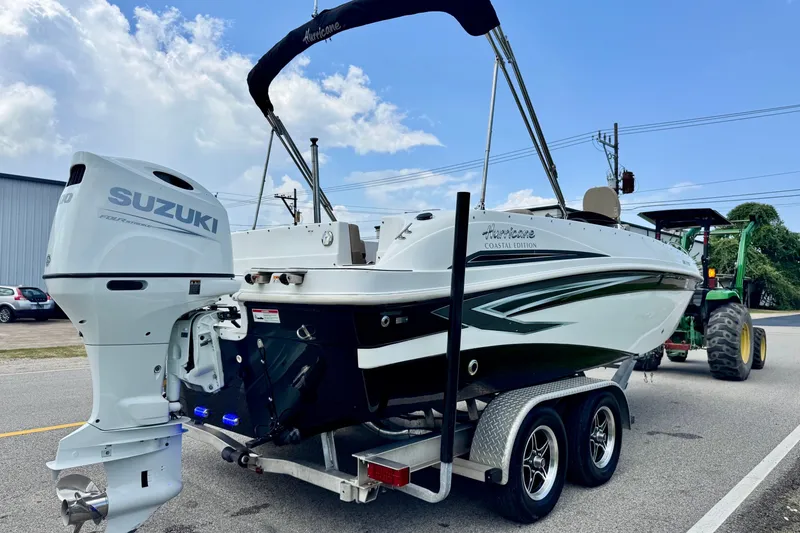 Slide: The Image of 2022 Hurricane Sundeck Sport 218 OB boat with Suzuki outboard motor on trailer. - 4
