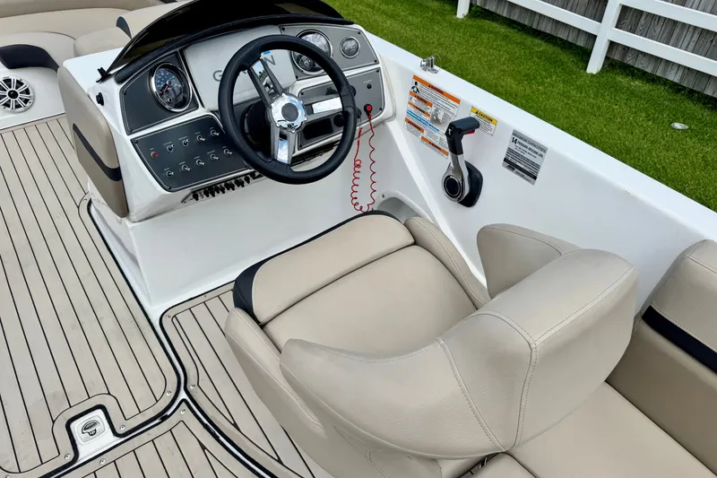 Slide: The Image of 2022 Hurricane Sundeck Sport 218 OB boat cockpit with steering wheel and controls. - 8