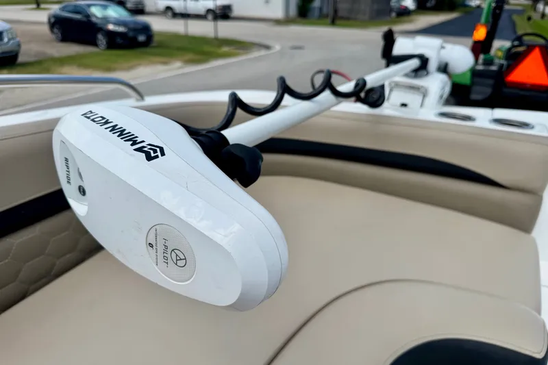Slide: The Image of Minn Kota trolling motor on 2022 Hurricane Sundeck Sport 218 OB boat, parked in residential area. - 12