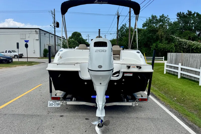 Slide: The Image of 2022 Hurricane Sundeck Sport 218 OB boat on trailer, parked on a suburban street. - 3