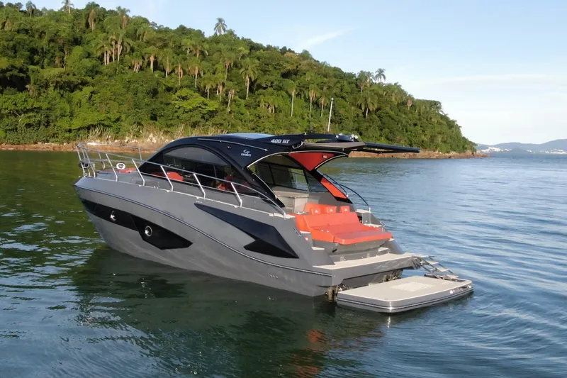 The Image of 2024 Evolve 400HT luxury yacht on serene water near lush green coastline. - 1