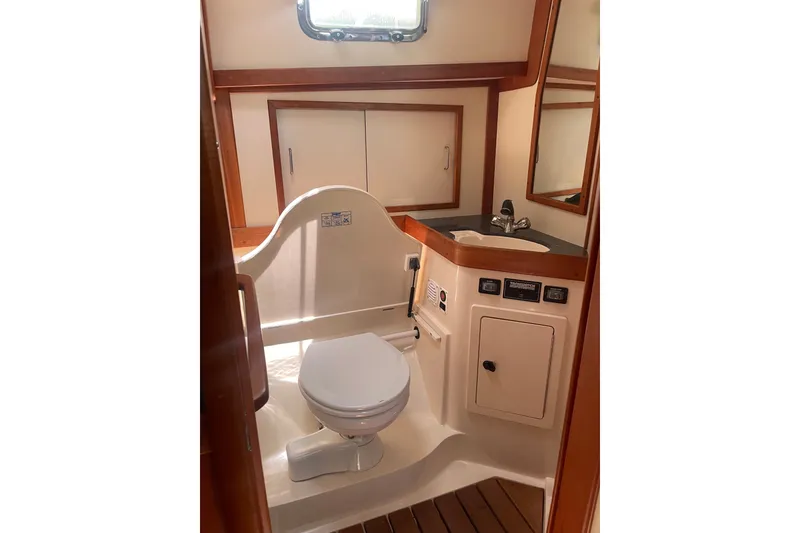 Slide: The Image of 2001 Sabre 36 Express yacht bathroom with toilet, sink, and wooden accents. - 25