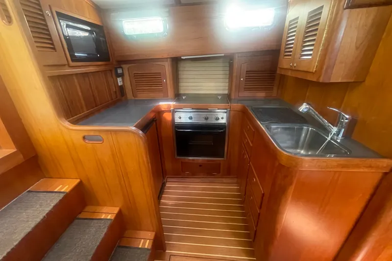 Slide: The Image of 2001 Sabre 36 Express yacht interior kitchen with wood cabinetry and stainless steel sink. - 15