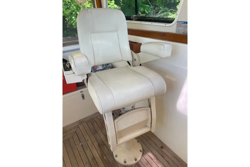 Slide: The Image of White captain's chair on 2001 Sabre 36 Express boat, wooden deck visible. - 9