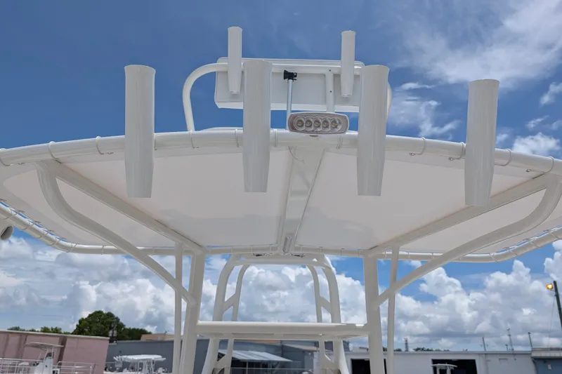 Slide: The Image of T-top of 2027 Pathfinder 2700 Tournament boat with rod holders under a blue sky. - 23