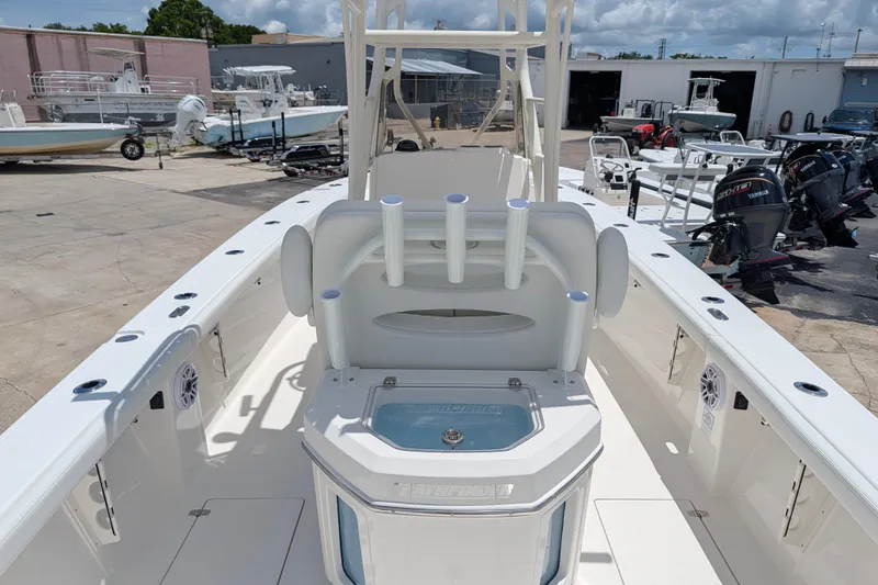 Slide: The Image of 2027 Pathfinder 2700 Tournament boat interior with rod holders and storage, in a marina setting. - 8
