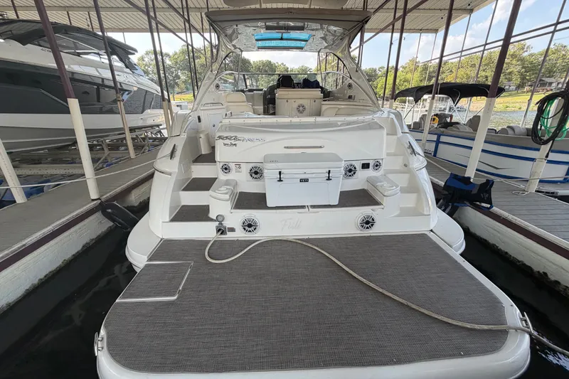 Slide: The Image of 2006 Cruisers Yachts 560 Express docked, showcasing spacious deck and seating area. - 10