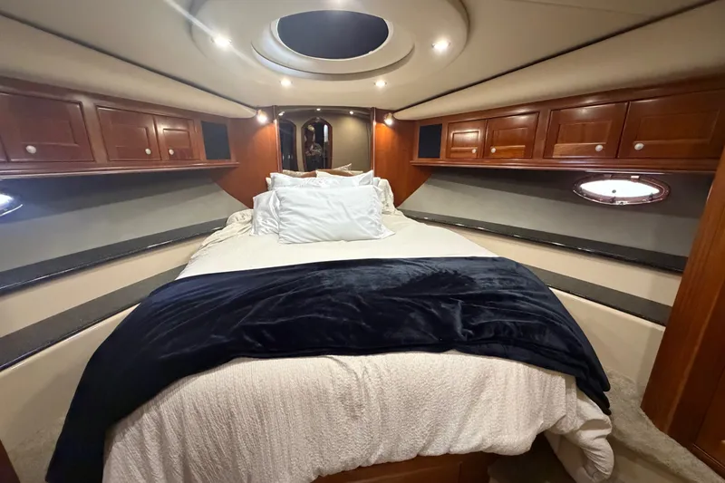 Slide: The Image of Luxurious 2006 Cruisers Yachts 560 Express bedroom with elegant wood cabinetry and plush bedding. - 14
