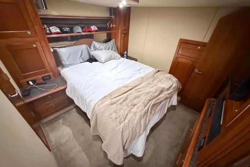 Slide: The Image of Luxurious bedroom interior of 2006 Cruisers Yachts 560 Express with cozy bedding and wooden cabinetry. - 12