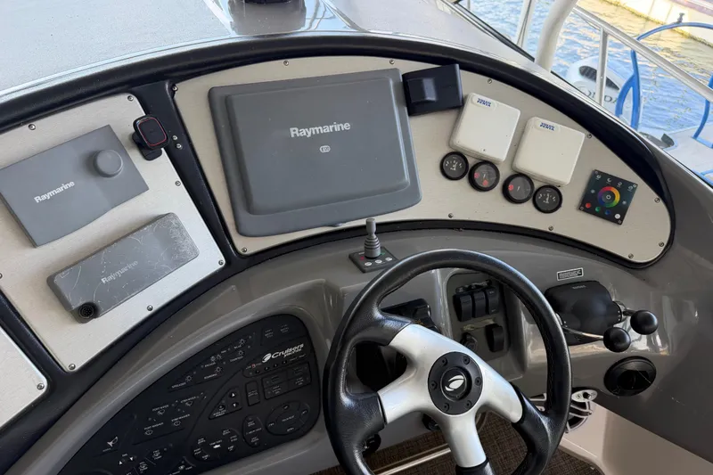 Slide: The Image of 2006 Cruisers Yachts 560 Express helm with Raymarine navigation equipment and steering wheel. - 5