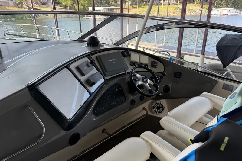Slide: The Image of 2006 Cruisers Yachts 560 Express helm with modern controls and scenic marina view. - 4