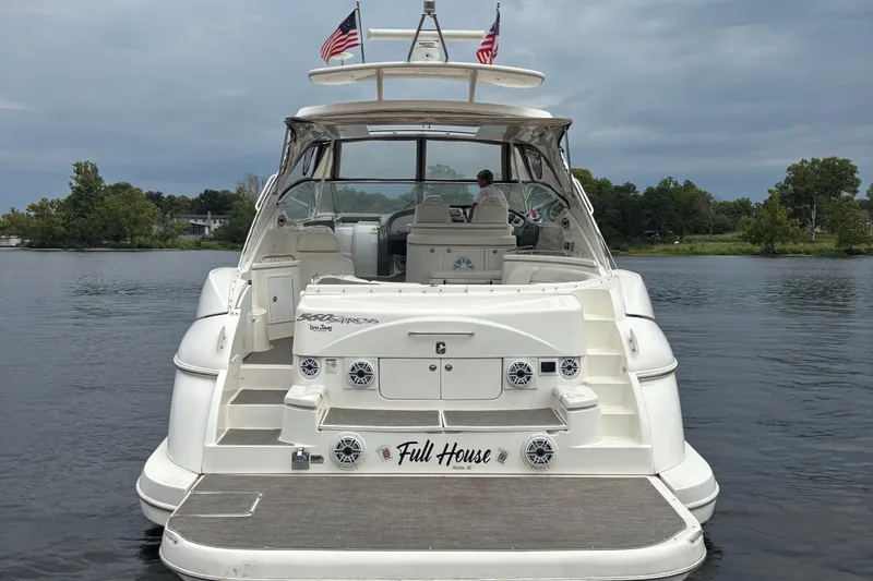 Slide: The Image of 2006 Cruisers Yachts 560 Express on water, rear view with American flags. - 2