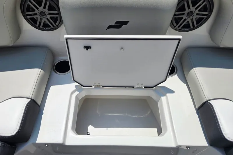 Slide: The Image of 2024 Starcraft SVX 231 OB boat interior with open storage compartment and speakers. - 9