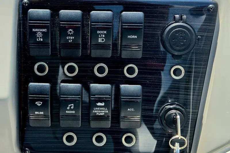 Slide: The Image of Control panel of 2024 Starcraft SVX 231 OB boat with switches and USB port. - 39
