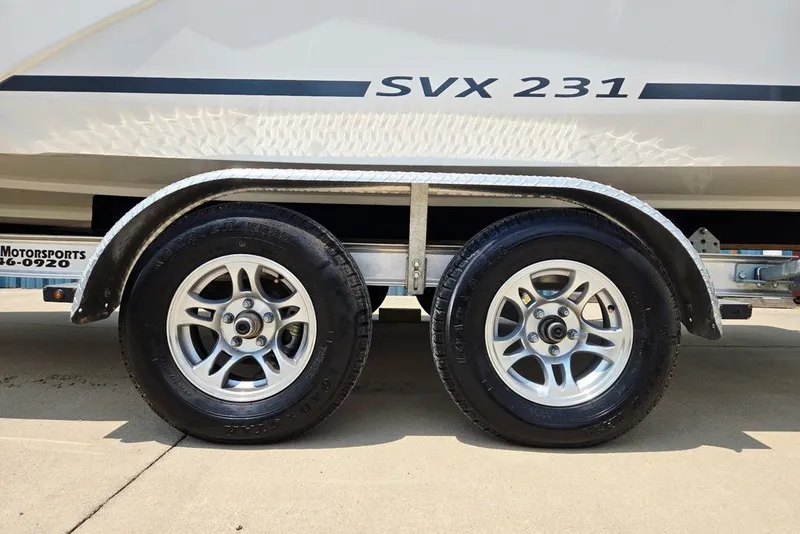 Slide: The Image of 2024 Starcraft SVX 231 OB boat trailer with dual wheels on concrete surface. - 10