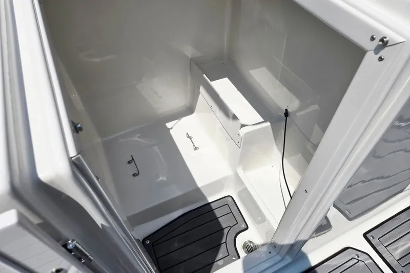 Slide: The Image of 2024 Starcraft SVX 231 OB boat interior storage compartment with hooks and drainage. - 26
