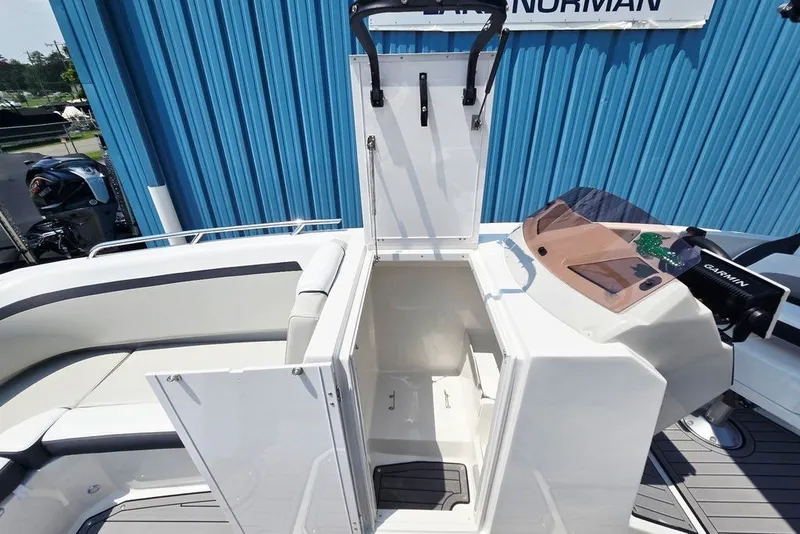 Slide: The Image of 2024 Starcraft SVX 231 OB boat interior with open storage compartment and seating. - 25