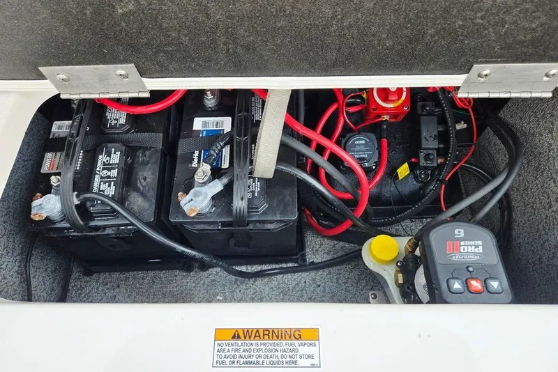 Slide: The Image of 2024 Starcraft SVX 231 OB boat battery compartment with wiring and warning label. - 56