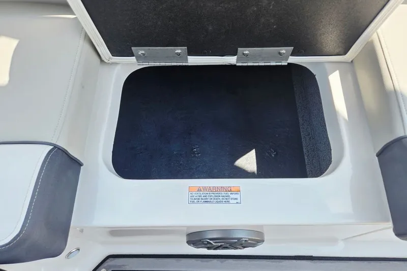 Slide: The Image of Open storage compartment on 2024 Starcraft SVX 231 OB boat with warning label visible. - 45