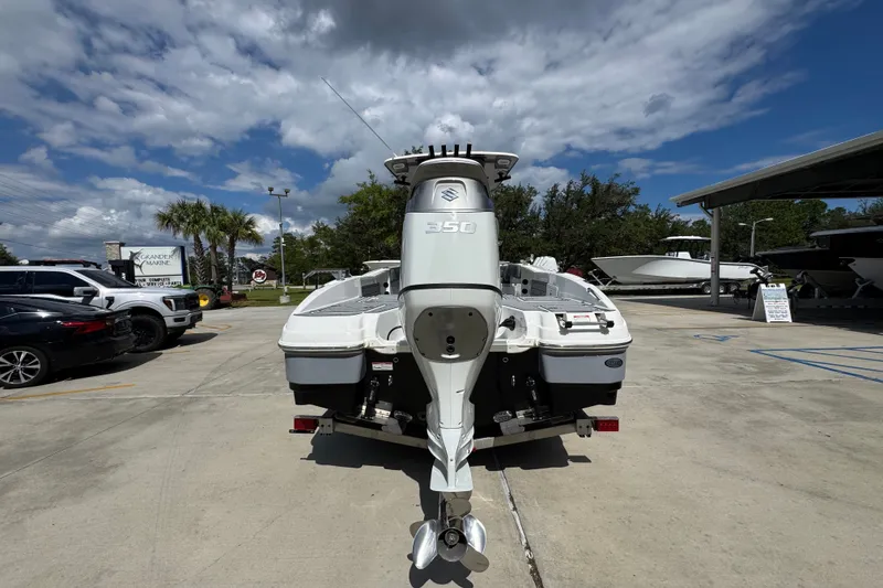 Slide: The Image of 2025 NauticStar 251 Hybrid boat with powerful outboard motor in a sunny dealership lot. - 15