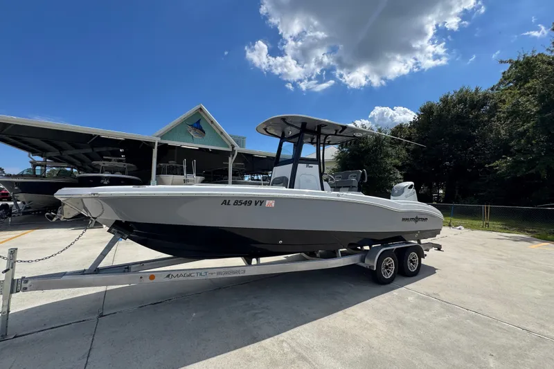 Slide: The Image of 2025 NauticStar 251 Hybrid boat on trailer under clear sky at marina. - 3