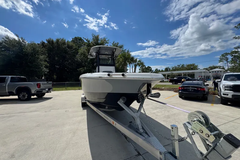 Slide: The Image of 2025 NauticStar 251 Hybrid boat on trailer in parking lot under blue sky. - 7