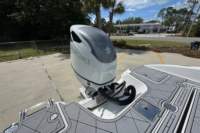Slide: The Image of 2025 NauticStar 251 Hybrid boat with Suzuki outboard motor in a parking area. - 44