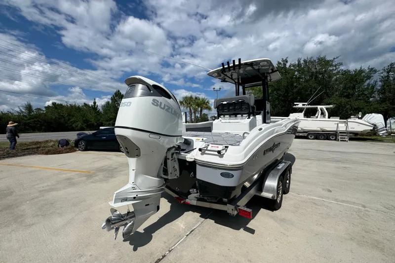 Slide: The Image of 2025 NauticStar 251 Hybrid boat with Suzuki engine on trailer under cloudy sky. - 13