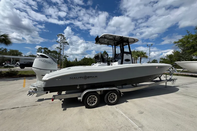 Slide: The Image of 2025 NauticStar 251 Hybrid boat on trailer under a partly cloudy sky. - 11