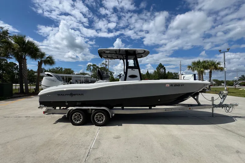 Slide: The Image of 2025 NauticStar 251 Hybrid boat on trailer under a partly cloudy sky. - 10