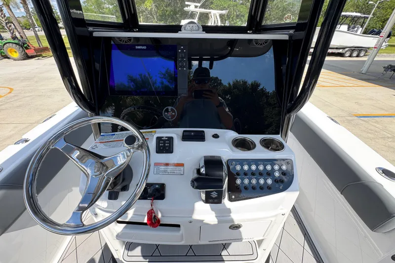 Slide: The Image of 2025 NauticStar 251 Hybrid boat dashboard with steering wheel and control panel. - 34