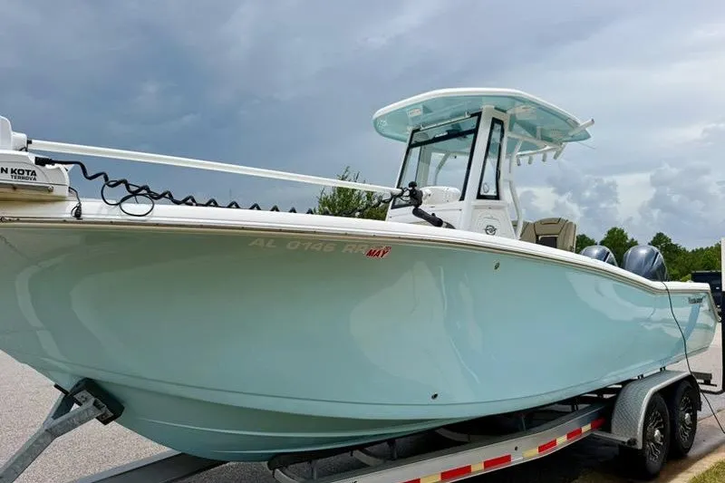 The Image of 2022 Tidewater 272 CC Adventure boat on trailer under cloudy sky. - 1