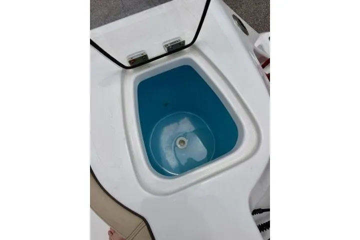 Slide: The Image of Livewell on 2022 Tidewater 272 CC Adventure boat, open lid, blue interior. - 15