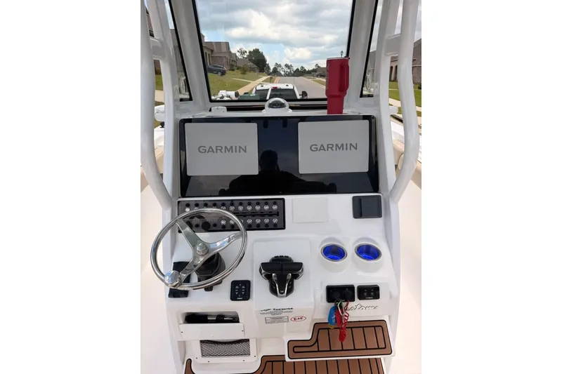 Slide: The Image of 2022 Tidewater 272 CC Adventure boat dashboard with Garmin displays and steering wheel. - 7