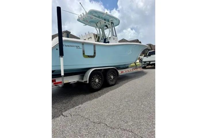 Slide: The Image of 2022 Tidewater 272 CC Adventure boat on trailer, parked on a residential street. - 3