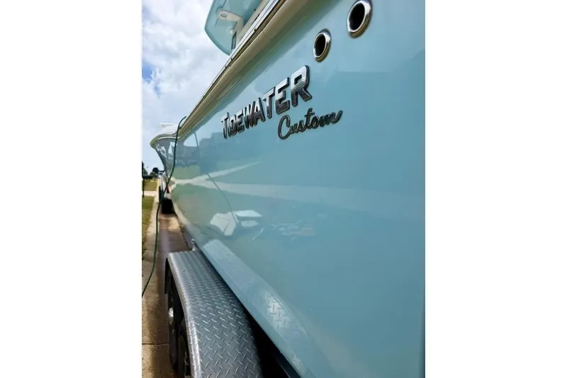 Slide: The Image of 2022 Tidewater 272 CC Adventure boat, light blue hull, parked on trailer. - 2