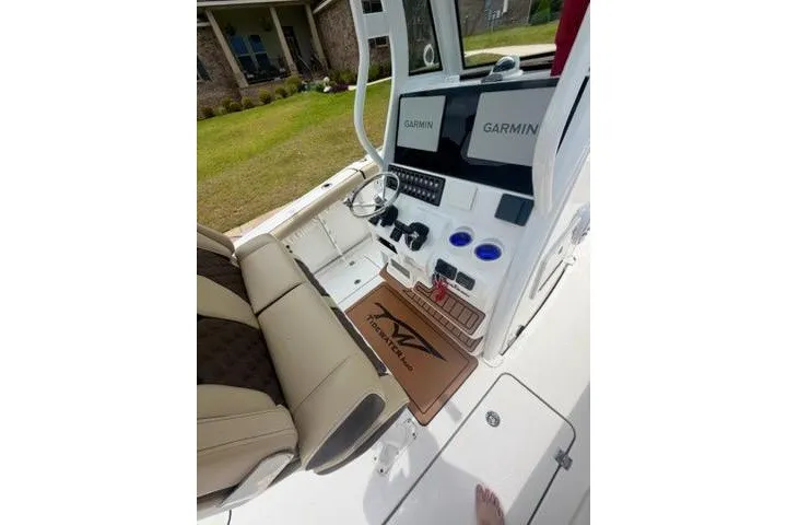Slide: The Image of 2022 Tidewater 272 CC Adventure boat cockpit with Garmin displays and seating. - 14