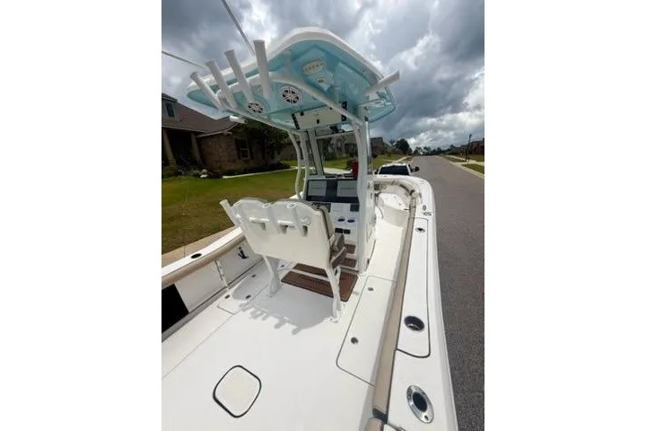 Slide: The Image of 2022 Tidewater 272 CC Adventure boat with modern console and seating on a residential street. - 17