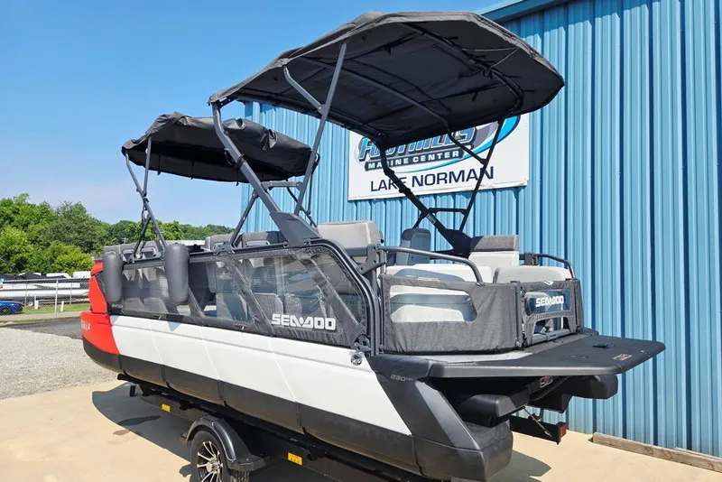 Slide: The Image of 2023 Sea-Doo Switch Cruise 21 pontoon boat with canopy, displayed at a marine center. - 13