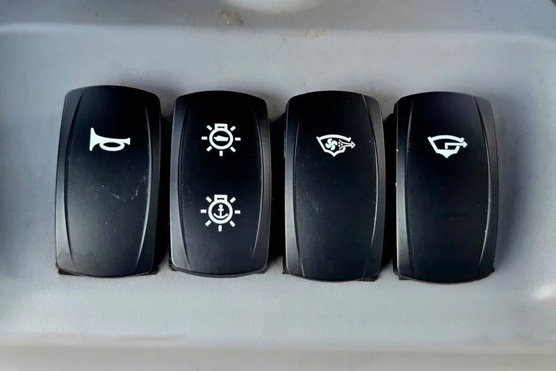 Slide: The Image of Control panel switches on a 2023 Sea-Doo Switch Cruise 21 boat. - 2