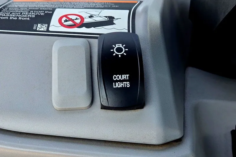 Slide: The Image of 2023 Sea-Doo Switch Cruise 21 dashboard with court lights switch and safety warning. - 7