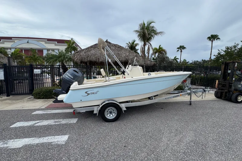 Slide: The Image of 2027 Scout 188 Sportfish boat on trailer, parked near tropical setting. - 3