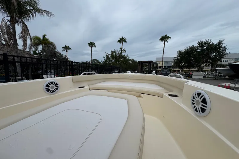 Slide: The Image of 2027 Scout 188 Sportfish boat interior with seating and speakers, surrounded by palm trees. - 7