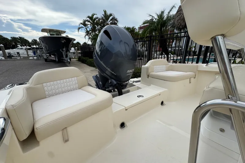 Slide: The Image of 2027 Scout 188 Sportfish boat interior with Yamaha outboard motor, docked near palm trees. - 11